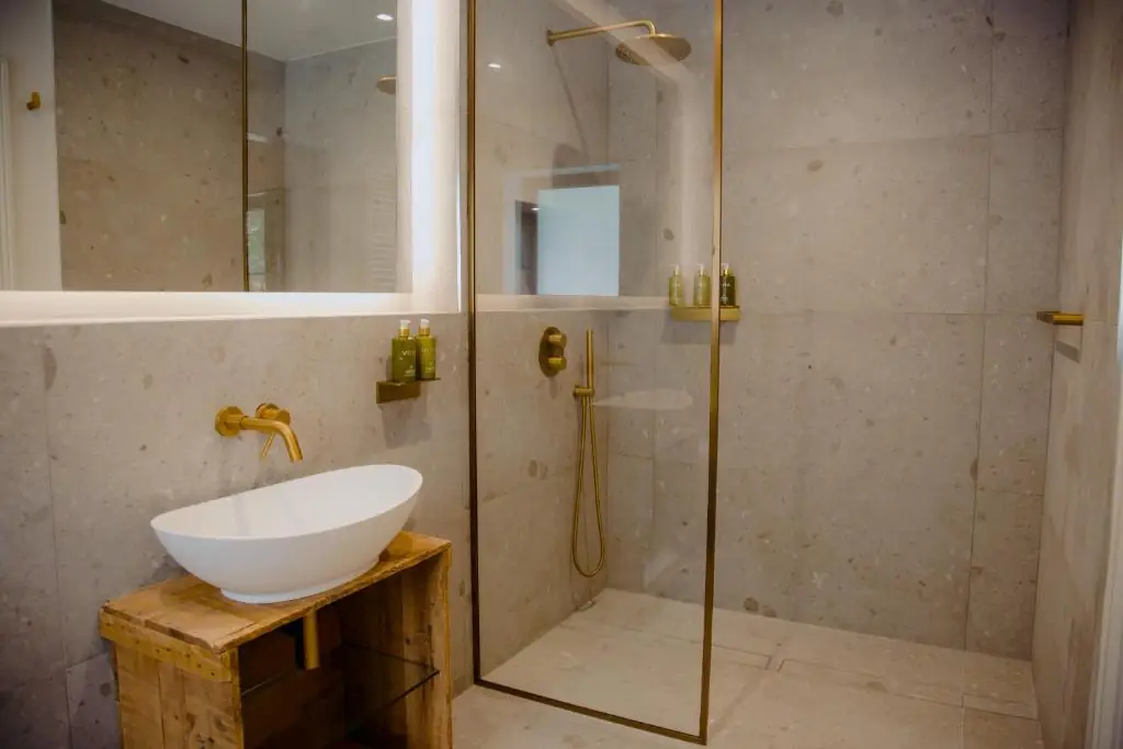 Ensuite bathroom with stone walls and brass fittings