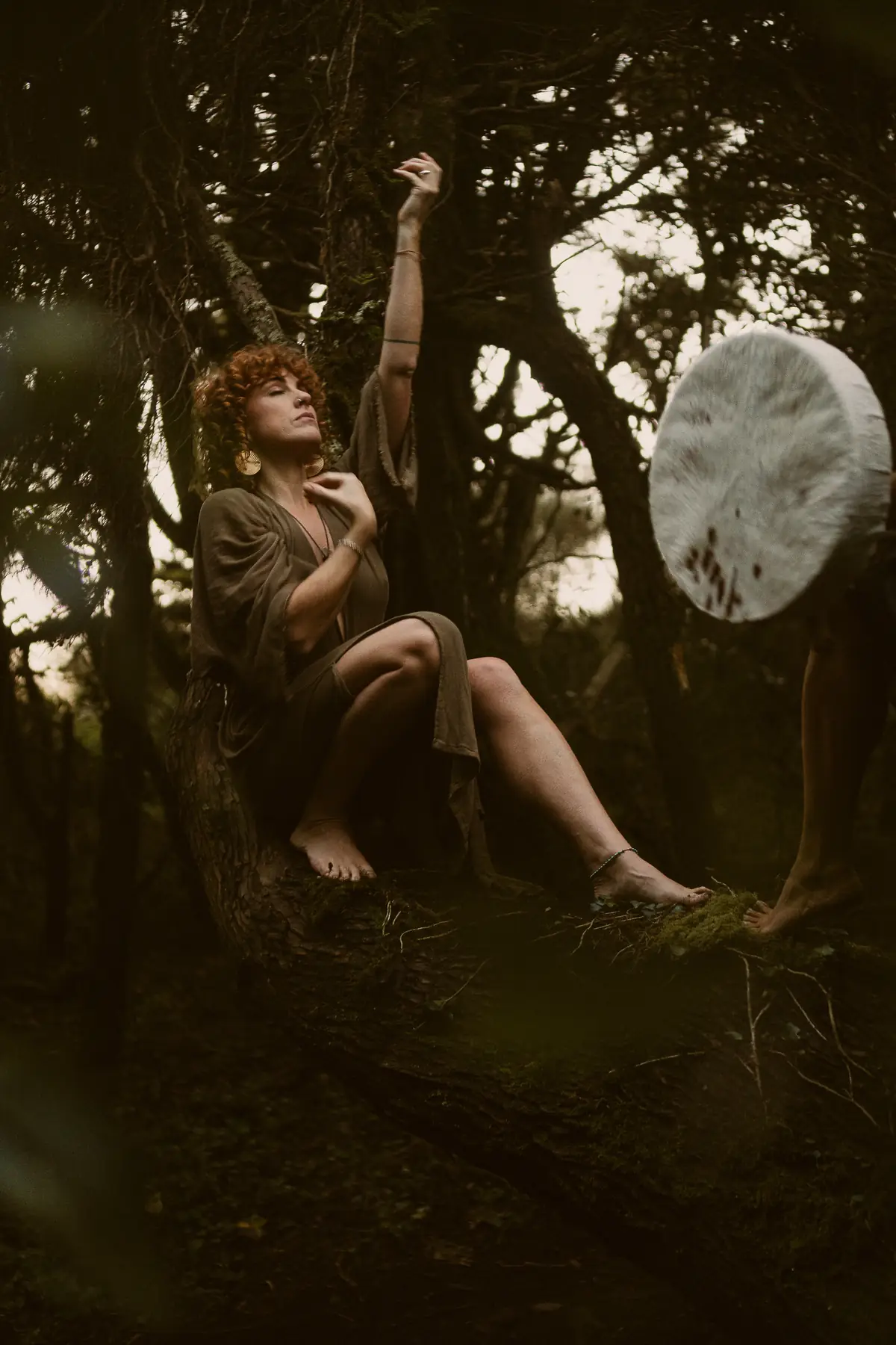 A woman resting in the trees, a drum beside her